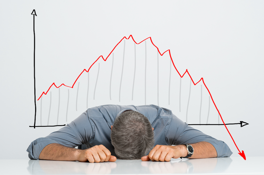 Crashing chart and person with head on a table