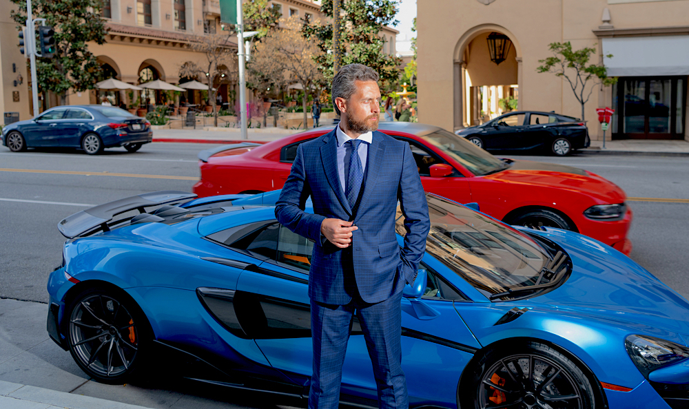 real estate agent in formal suit standing near luxury automobile